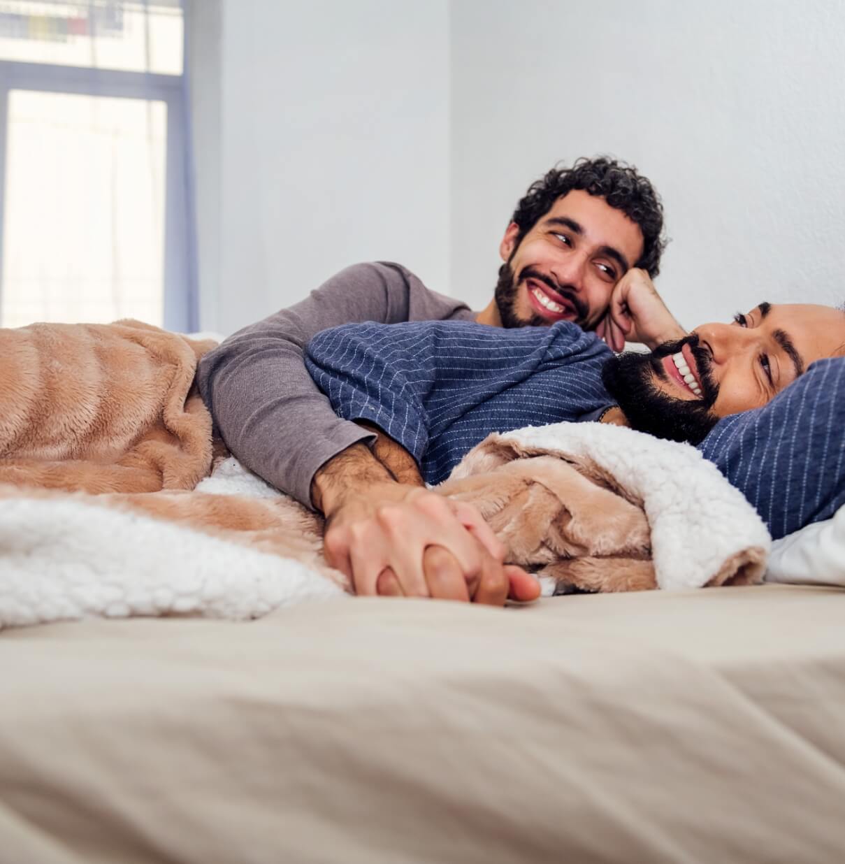gay-male-couple-relaxing-on-bed-with-clasped-hands-2025-03-09-15-15-26-utc (1)
