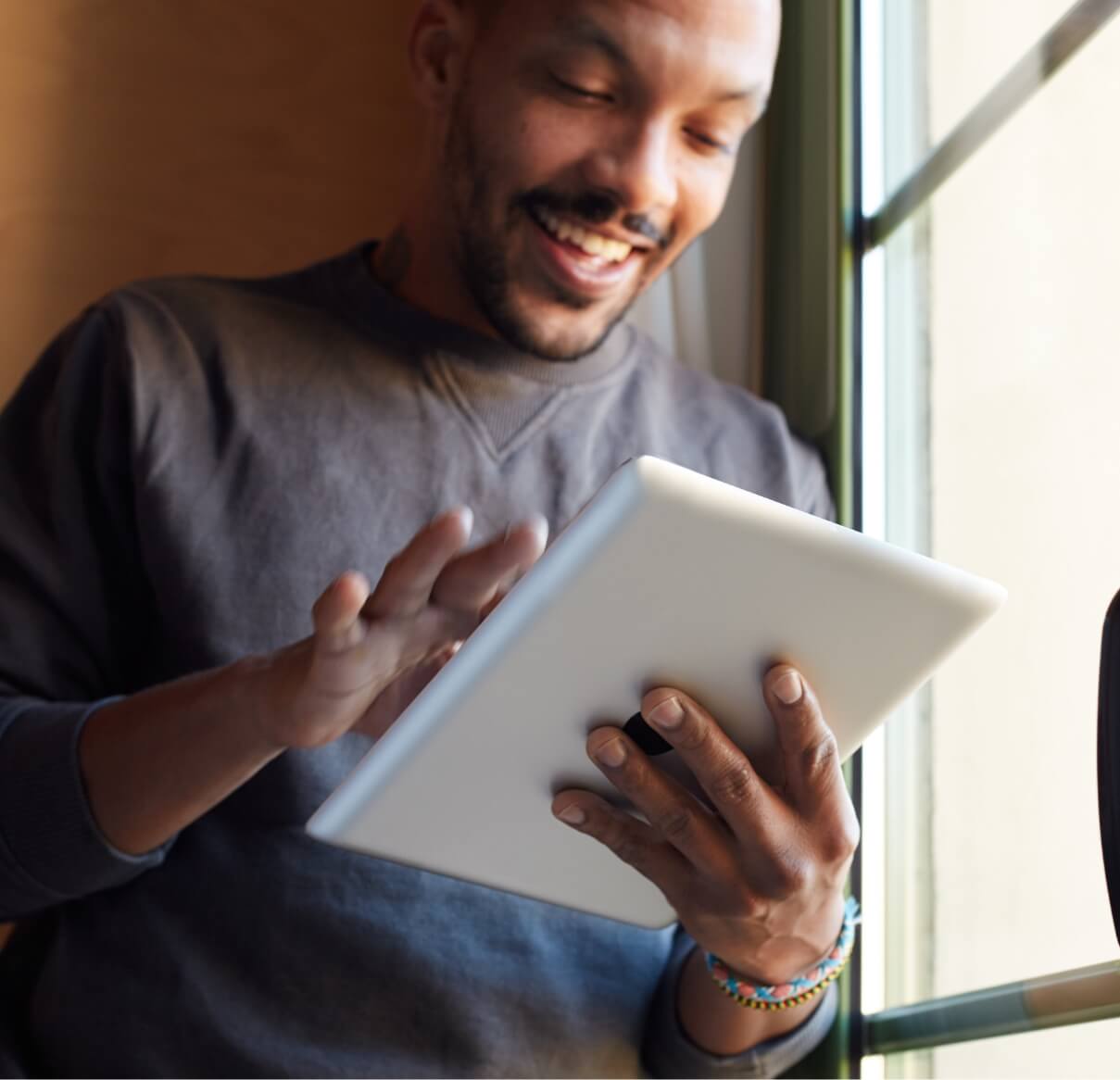 smiling-african-black-man-using-tablet-at-home-liv-2023-11-27-05-13-33-utc (1)