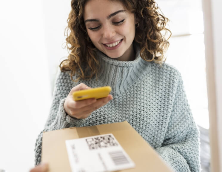 woman-with-curly-hair-scanning-a-qr-code-with-her-2022-11-09-05-09-32-utc (1)